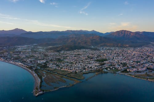 Aerial View of a Coastal City and Mountains in the Horizon 