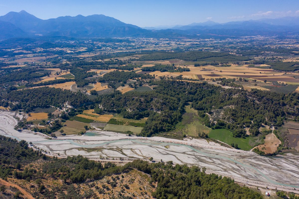 Vedere aeriană cu terenuri agricole și munți în fundal