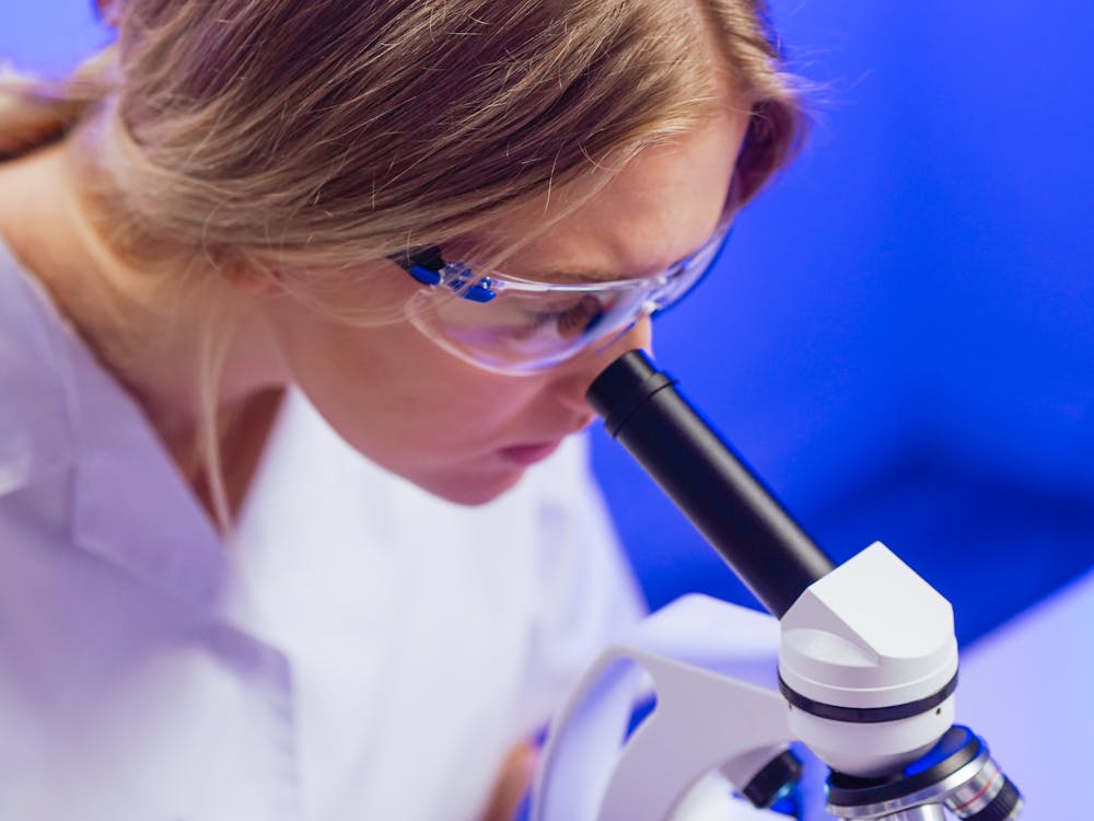 Free A Woman Looking into the Microscope Stock Photo