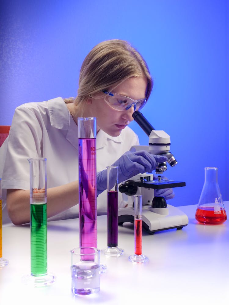 A Woman Examining A Microscope Slide