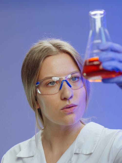 Free Woman Holding an Erlenmeyer Flask with Red Liquid Stock Photo