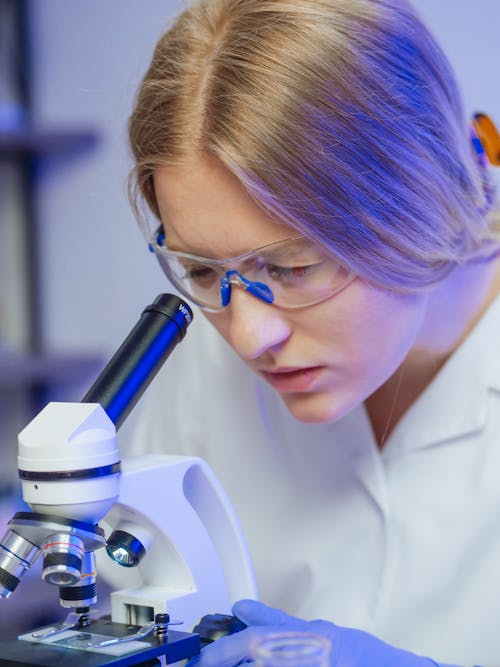 Close-Up View of a Woman Examining a Microscope Slide