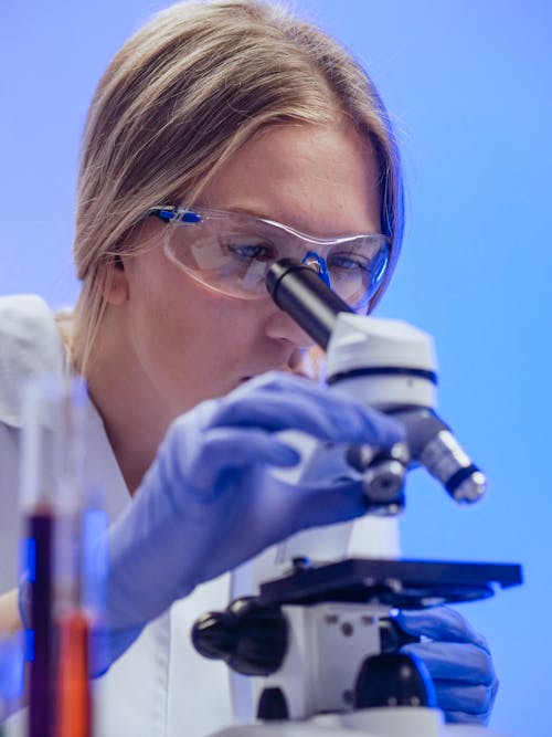 Close-Up View of a Woman Examining a Microscope Slide