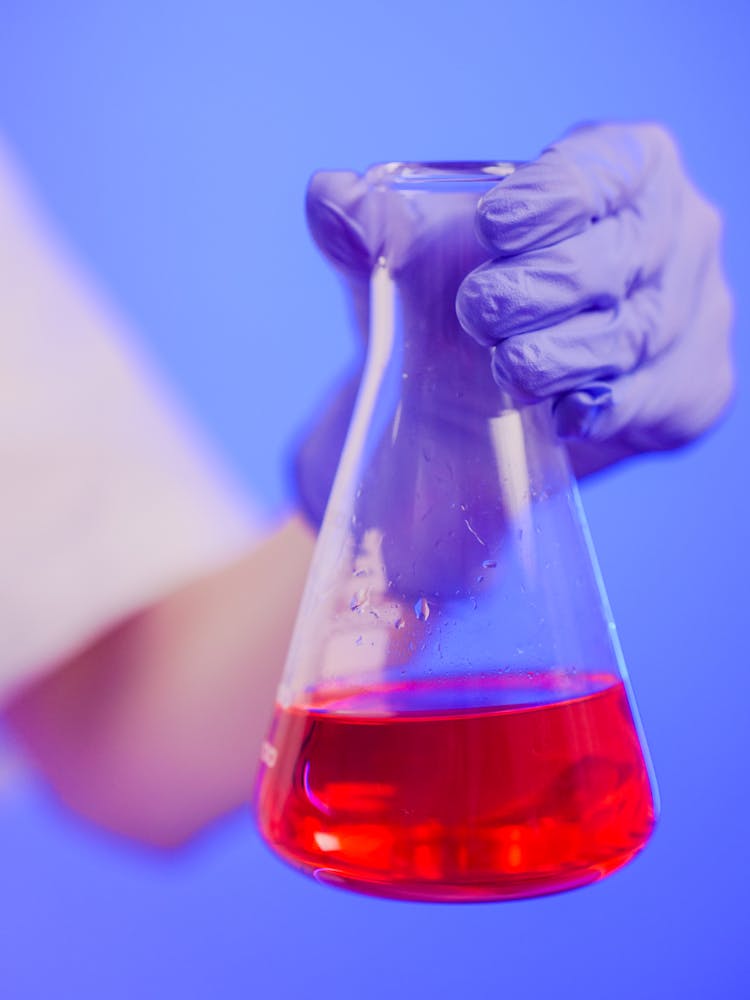 Close-Up Photo Of A Person Holding An Erlenmeyer Flask