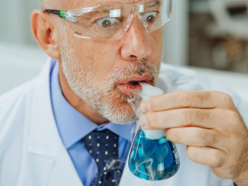 Close-Up View of a Man in White Coat Doing an Experiment