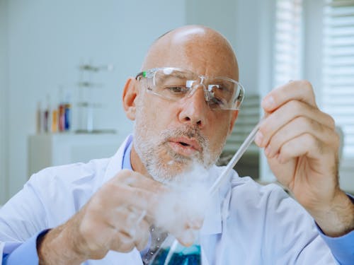 A Man in White Coat Doing an Experiment