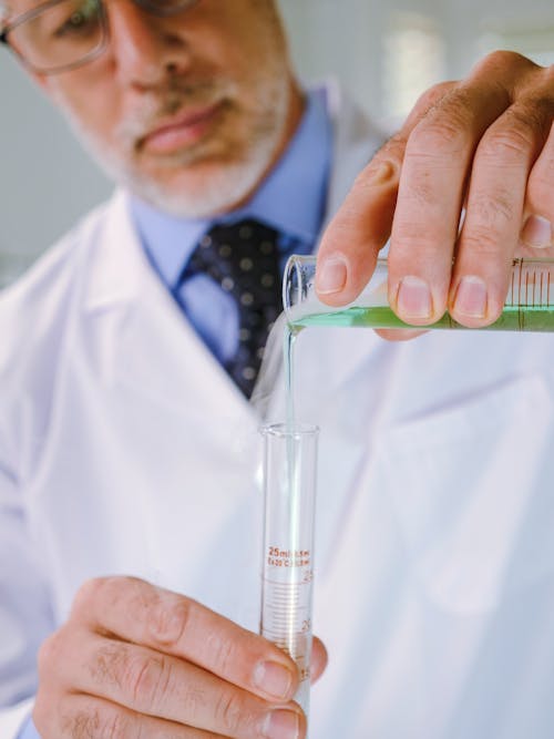 Close-Up View of a Man in White Coat Doing an Experiment