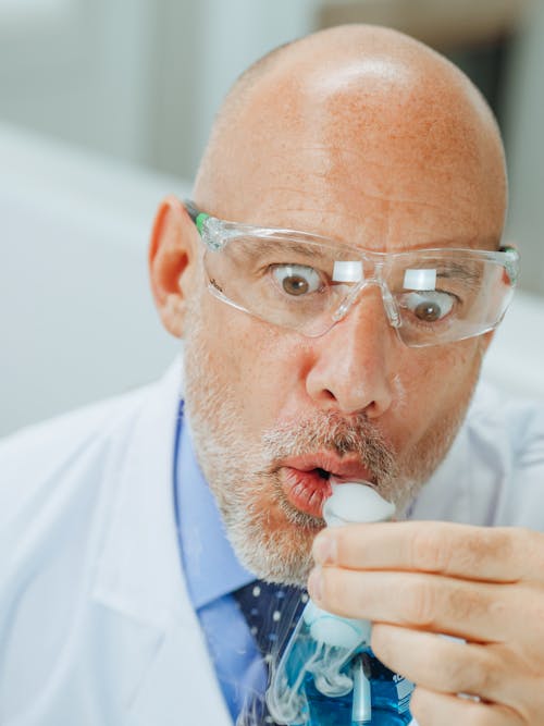 Close-Up View of a Man in White Coat Doing an Experiment