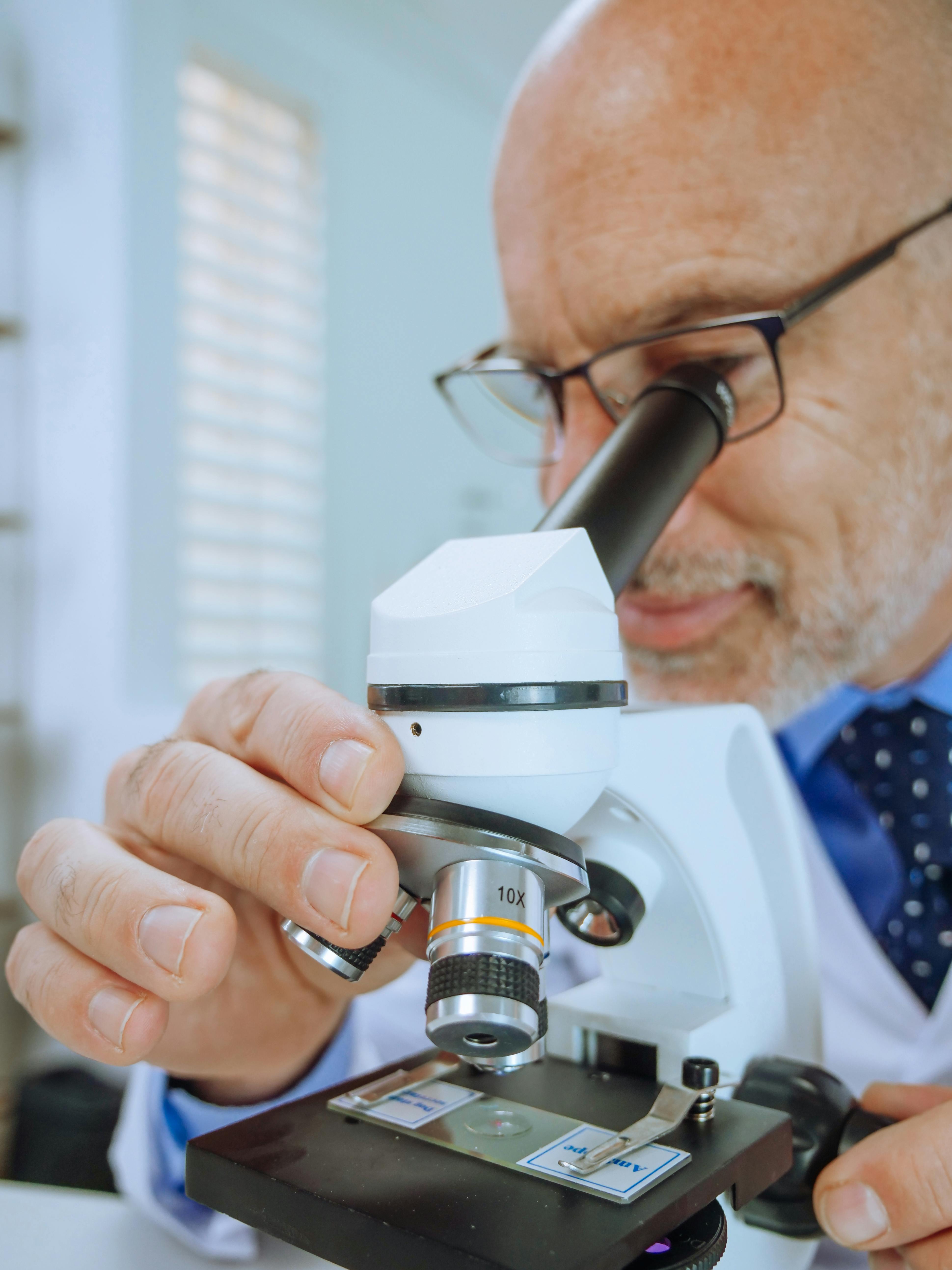 a man examining a microscope slide