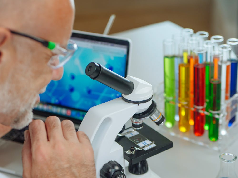a researcher examining a microscope slide.