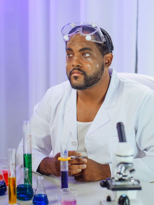 Free A scientist in a white lab coat using laboratory glassware for experiments. Stock Photo
