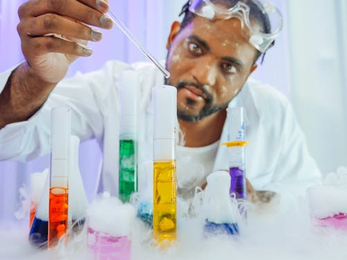 Free Man in White Coat Doing an Experiment Stock Photo
