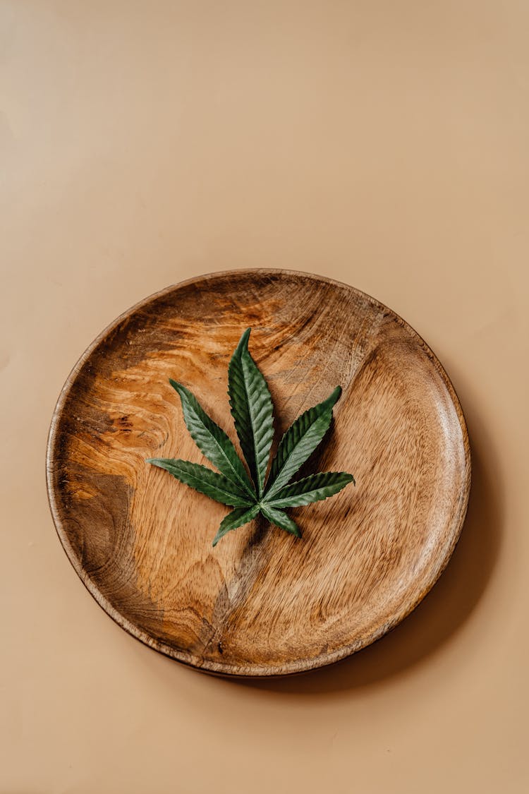 A Green Leaves On A Wooden Plate