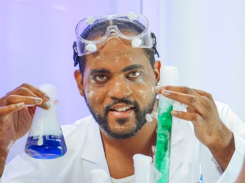 Free Scientist performing chemical experiments in laboratory with glass beakers. Stock Photo