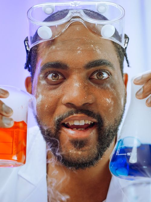 Free Excited scientist examining colorful chemical solutions in a laboratory setting. Stock Photo