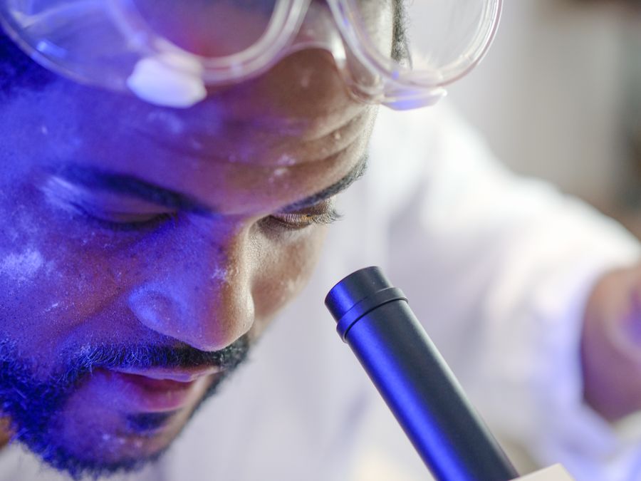Laboratory scientist examining a microscope slide