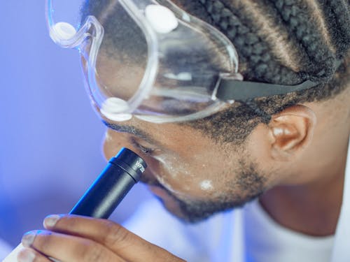 Close-Up View of a Man Looking into the Microscope