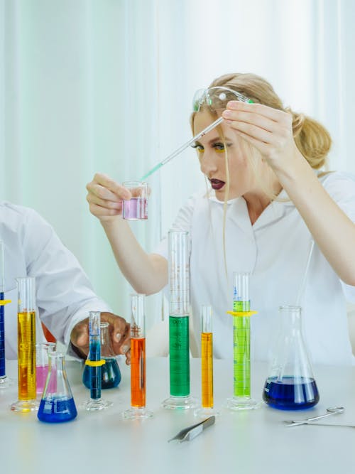 Free Woman in White Coat Doing an Experiment Stock Photo