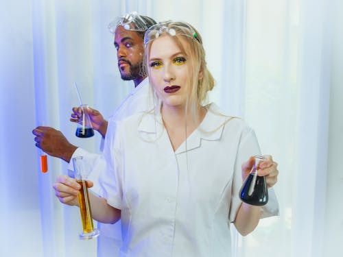 Man and Woman in White Coat Doing an Experiment