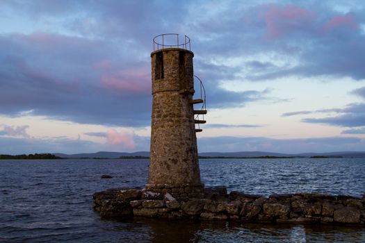 Concrete Lighthouse near Ocean under the Cloudy Sky