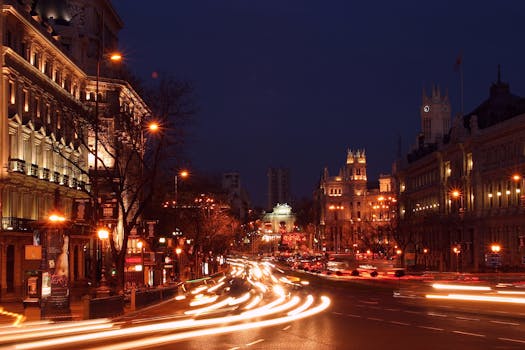 Explore the dynamic evening hustle of Madrid's downtown with blurred light trails and stunning architecture.
