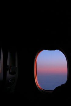 Beautiful sunrise view from an airplane window, showcasing vibrant sky colors.