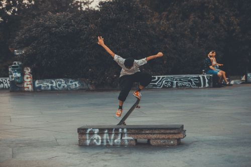 Free A dynamic skateboarding trick performed by a skater in an urban skatepark with vibrant graffiti. Stock Photo