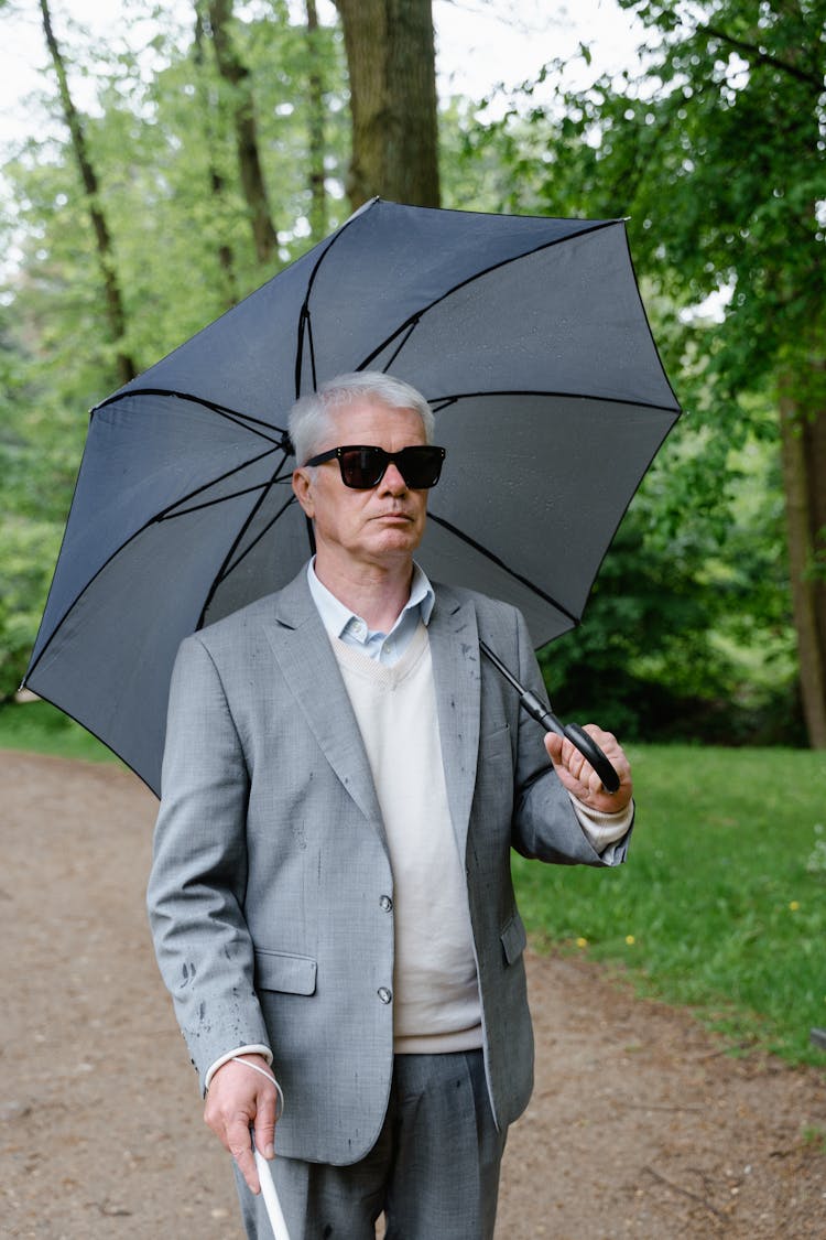 Man In Gray Suit Jacket Holding An Umbrella