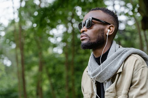 Close-Up Shot of a Man with Sunglasses Listening to Music