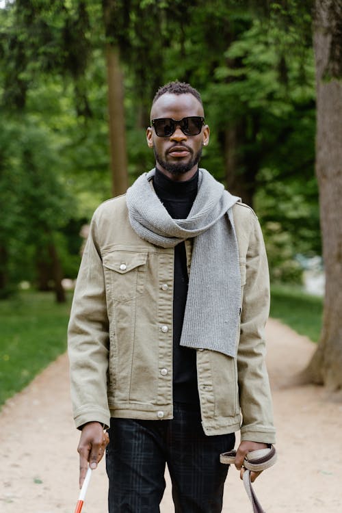 Man Wearing Jacket Holding a White Cane