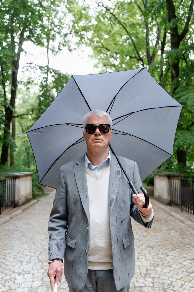 Photo Of A Man In Gray Suit Jacket Holding An Umbrella