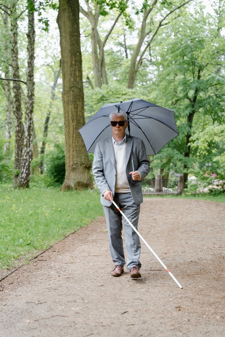 An Elderly Man Walking At A Park 