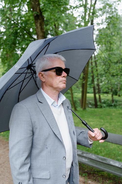 Man in Gray Suit Holding an Umbrella