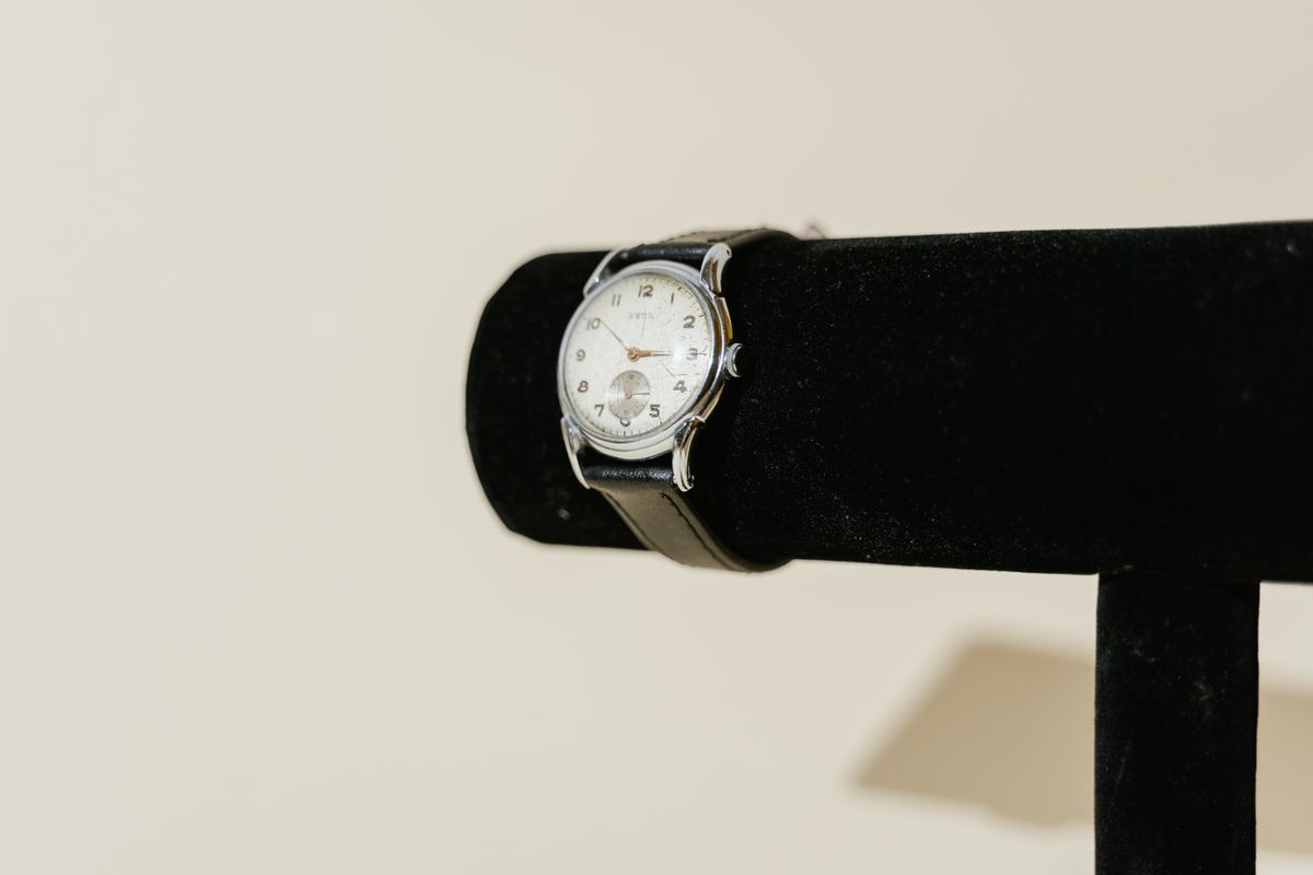Reloj vintage con correa de piel expuesto en soporte