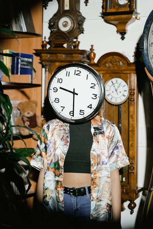 Free Person Covering her Face with a Wall Clock Stock Photo