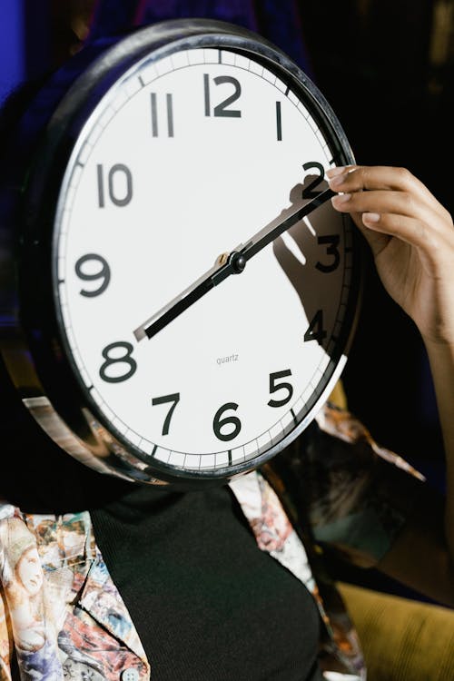 Hand Holding the Hand of a Clock 