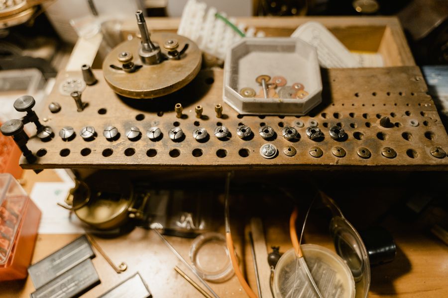 An inspection bench with measuring tools, parts trays and an angled lamp