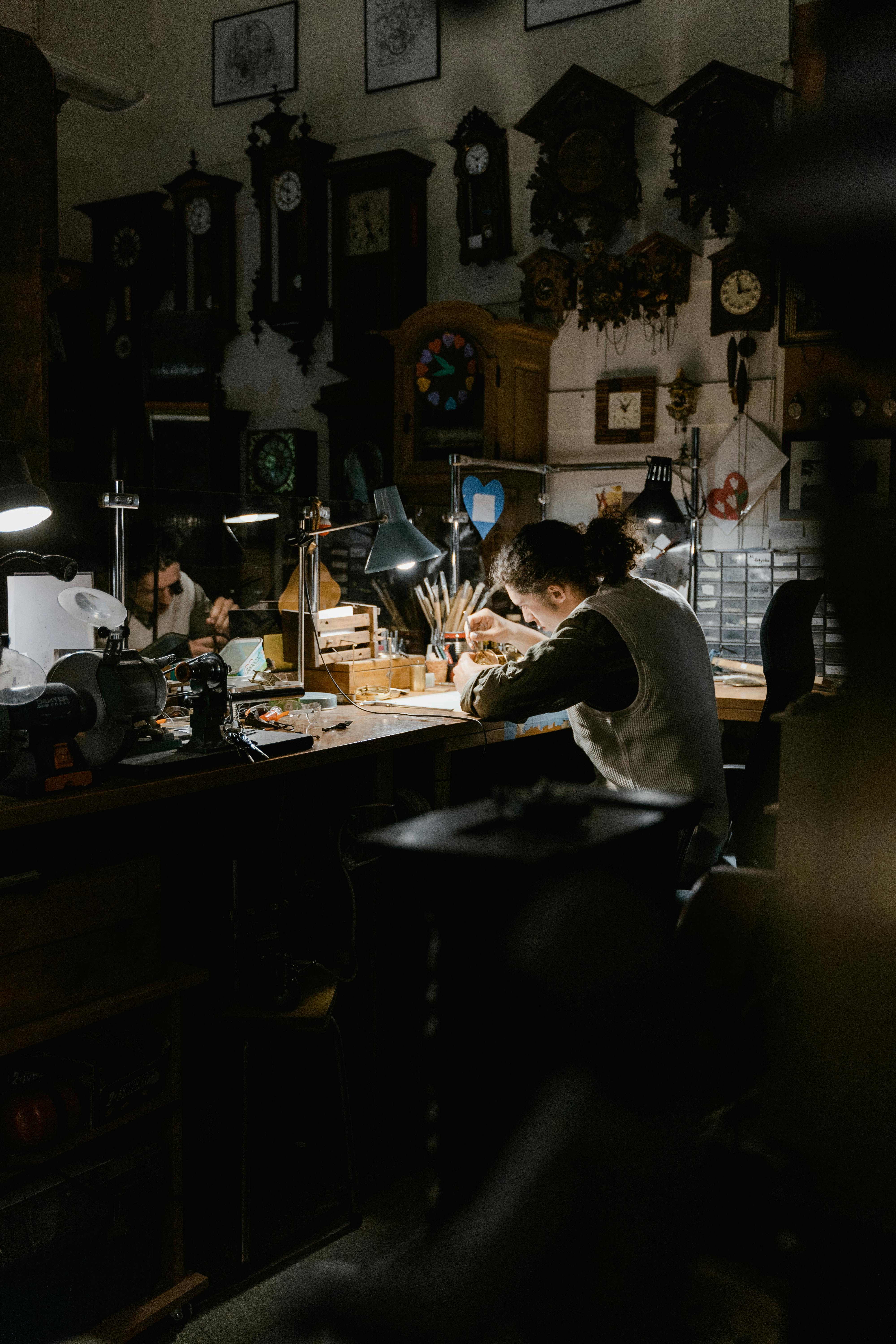 person sitting in black long sleeve working inside a watch shop