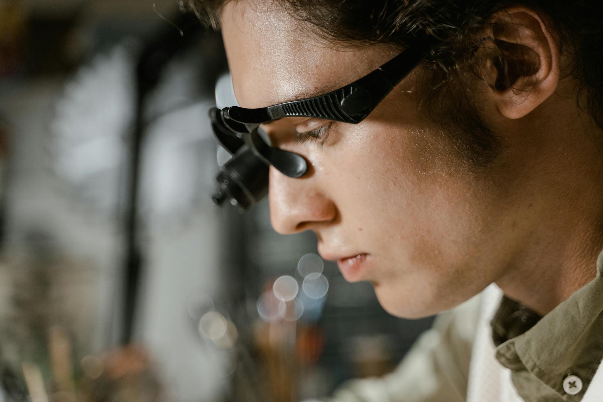 Close-up of a technician using a magnifying glass for precision work.