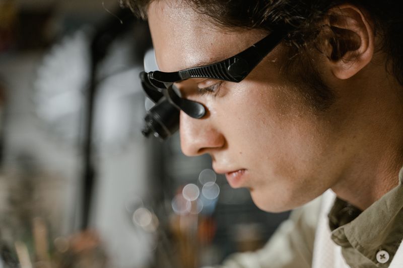 Close-up of a technician using a magnifying glass for precision work.