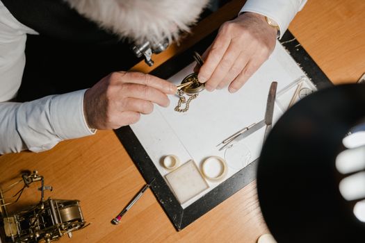 Close-up of a watchmaker's hands skillfully repairing a classic pocket watch.