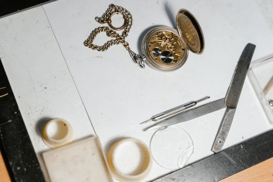 Pocket watch with tweezers on a bench