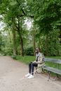 Man in Gray Jacket Sitting on Brown Wooden Bench