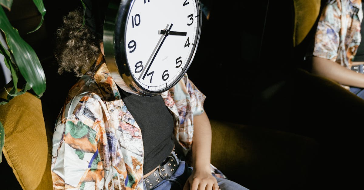Creative portrait of a person sitting with a large clock covering their face, indoors.
