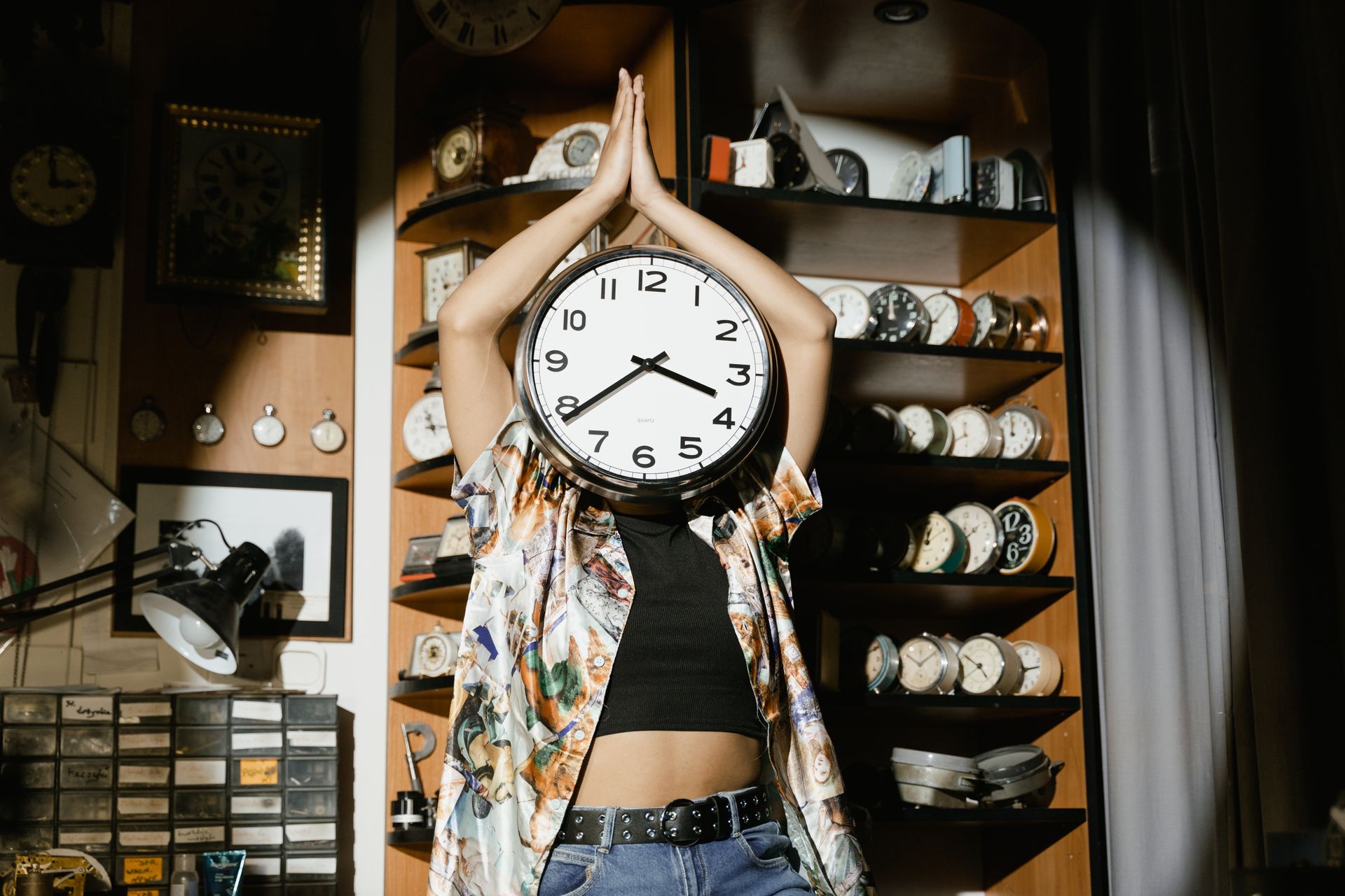 Woman with a Clock Head Doing Yoga in a Watch Repair Shop