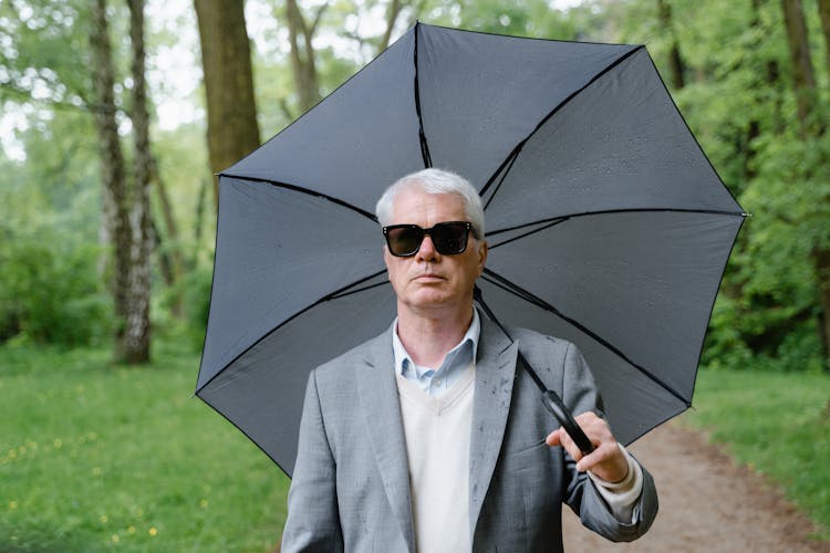 Man In Gray Suit Holding An Umbrella