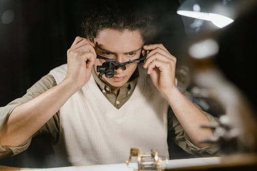 Watchmaker Repairing a Clock with his Loupe on 
