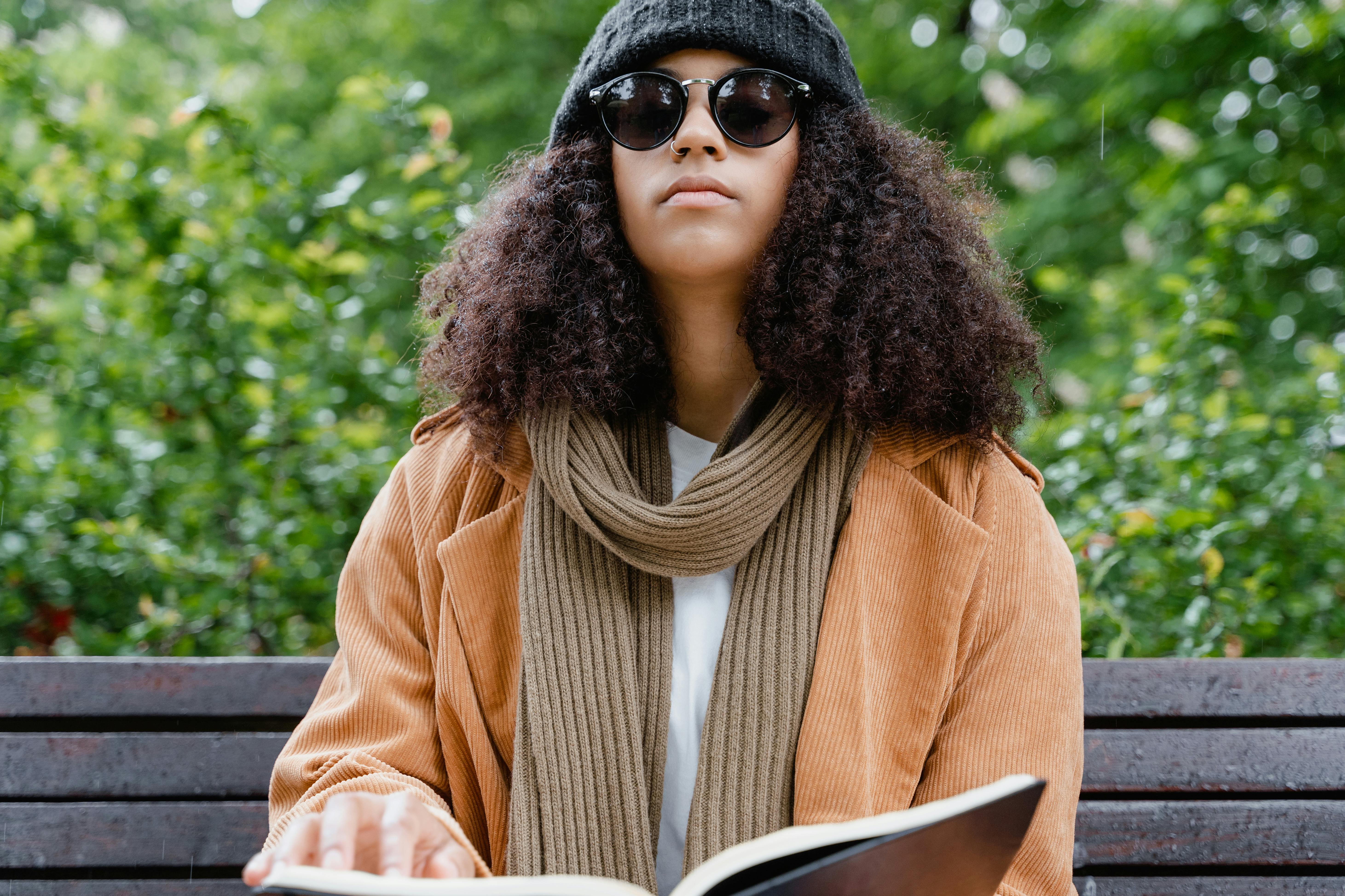 A woman with visual impairment reads a braille book outdoors.