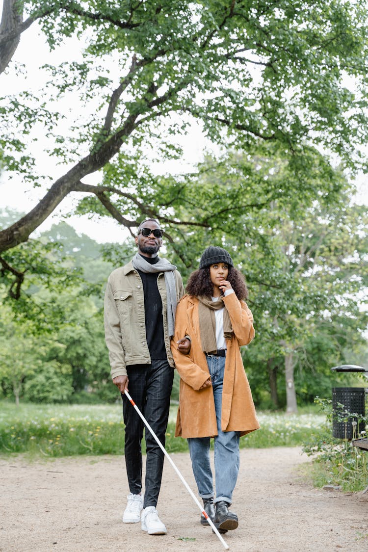 A Woman Walking With A Blind Man Together