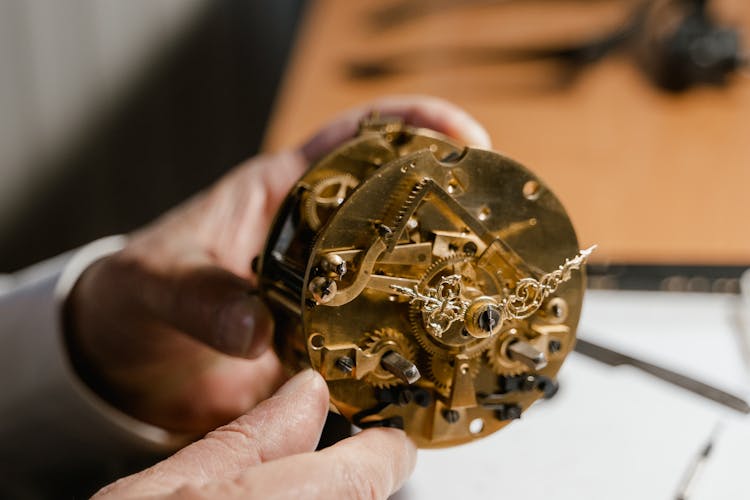 Person Fixing An Antique Timepiece